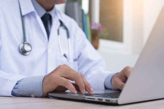 Doctor typing on computer
